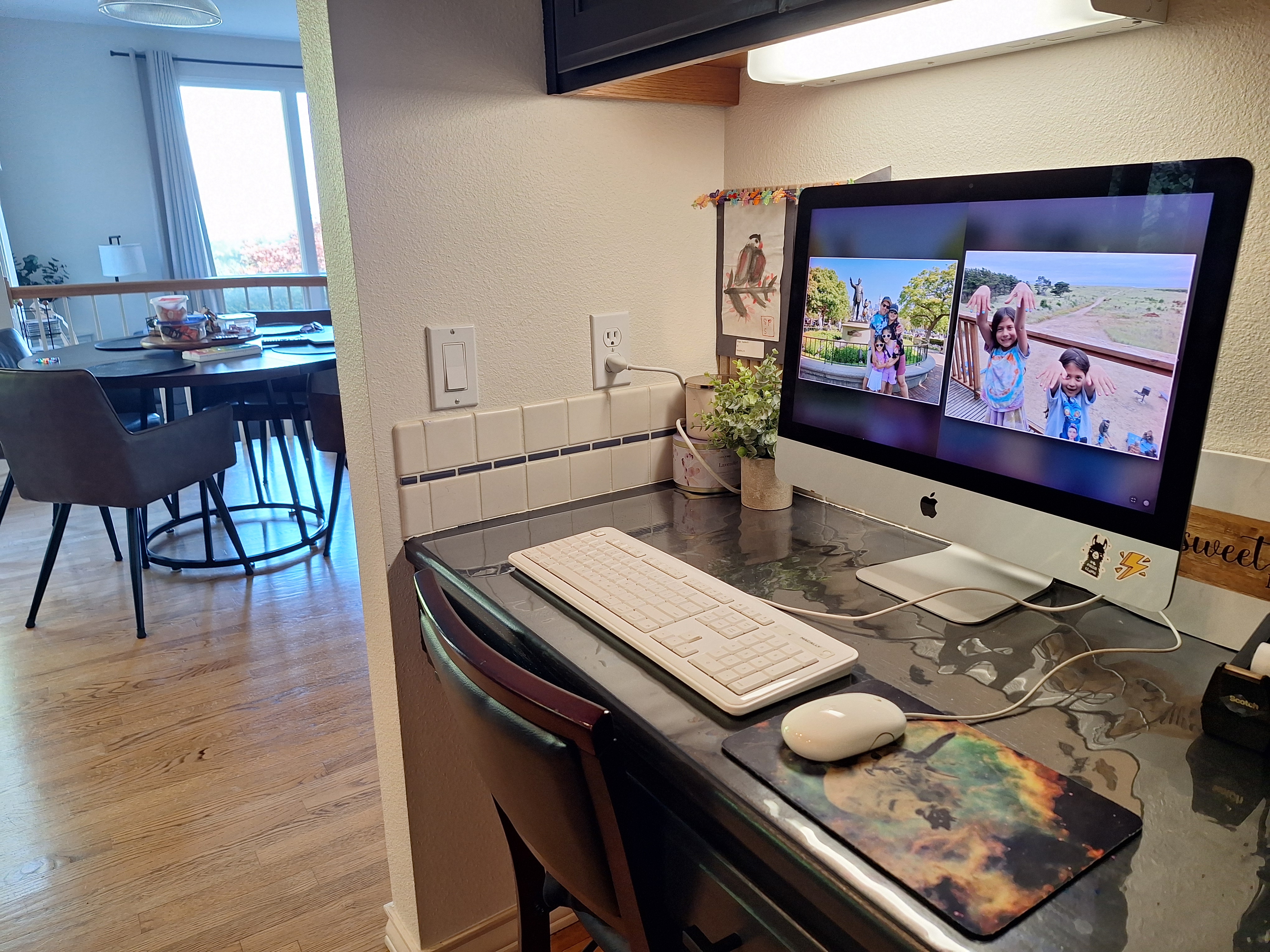 An iMac on the kitchen counter runs AnyFrame Dual View, showing two family photos side by side.